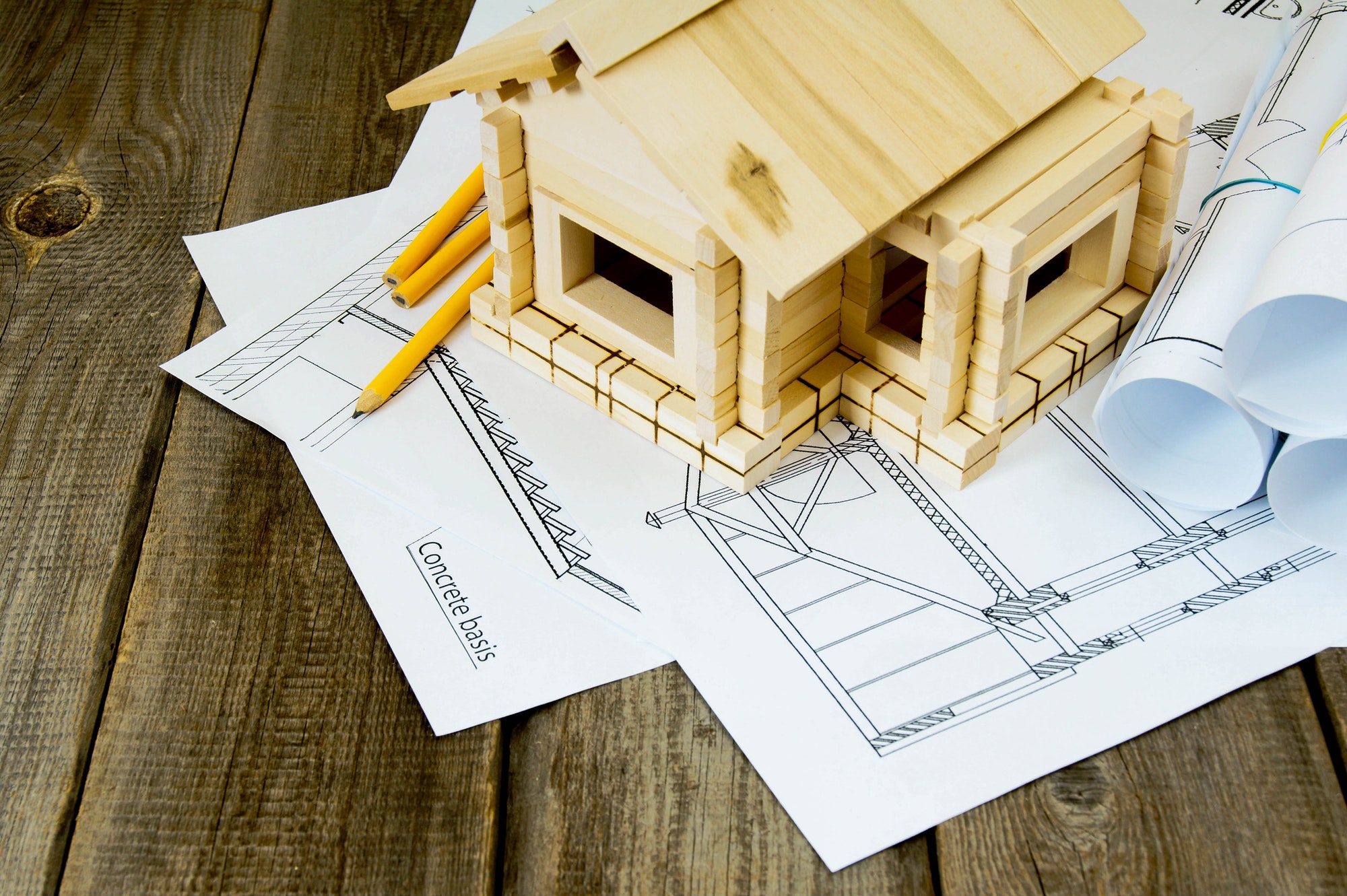Many drawings for building and small house on old wooden background.